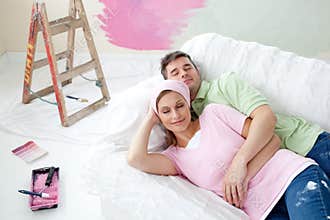 Couple relaxing after painting lying on the sofa