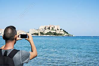 Man taking a picture of Calvi, in Corsica, France