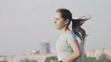 Russia, Izhevsk - Jul 2, 2018: Young woman runner training along pond. Fitness woman jogging outdoor