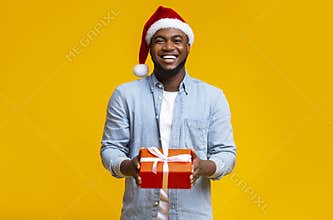 Handsome black guy in red Santa hat holding gift box