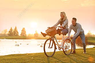 Happy young couple with bicycle having fun. Time for picnic