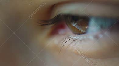 Woman hazel eye blinks extreme close up with blurry corner