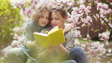 Spring portrait of mother and her teenage son on a background of blooming magnolia. Spring picnic, happy family