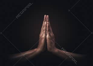 Praying hands with faith in religion and belief in God on dark background. Power of hope or love and devotion. Namaste or Namaskar