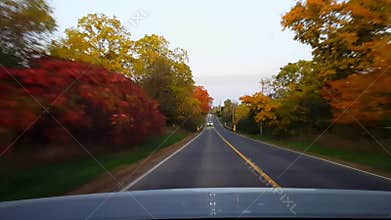 Rear view from back of car driving rural countryside road during autumn day. Car point of view POV behind vehicle country street
