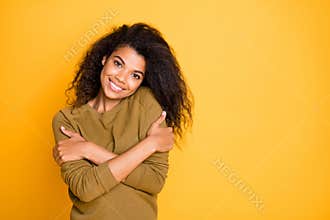 Photo of curly wavy cheerful nice charming positive girlfriend hugging herself smiling beaming with self love isolated
