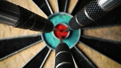 Three darts in the center of dartboard - set and achieve your aspirations and goals concept