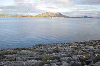 View to the sea and mountains in Torget island in Brønnøy, Nordland on summer evening