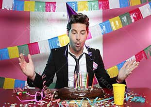 Blowing young man a holiday party chocolate cake