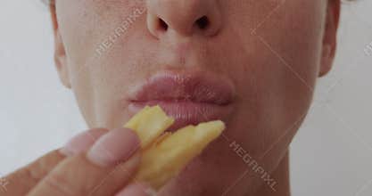 Woman eating french fries, unhealthy eating, close-up lips.
