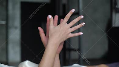 Young lovely couple hugging in bed. Boyfriend holding hand of his girlfriend, tenderness love