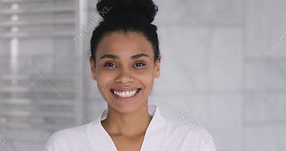 Happy young african woman looking at camera in bathroom