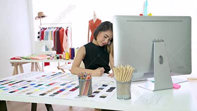 Young fashion designer sketching the new collection in modern studio