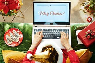 Elegant woman writing Merry Christmas email on laptop