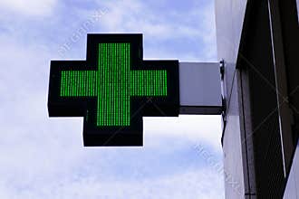Shop green cross logo Pharmacy sign in street modern building store