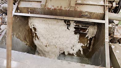 Clean cotton flowing inside a machine in a large industrial cotton gin