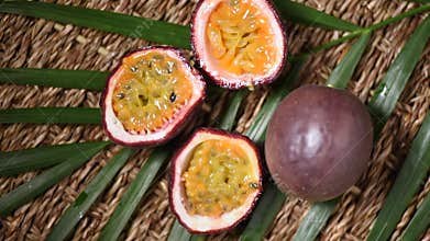 Passion fruits on rotating background. Top view. Exotic fruit, tropical palm branch. Vegan and raw food concept.