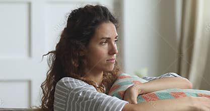 Nervous young woman embracing pillow regretting mistake abortion.