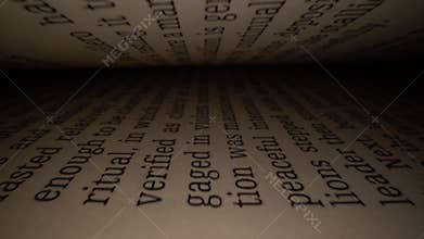 Dolly shot of camera sliding inside the book between letters. Latin letters and words on an open book with black dramatic