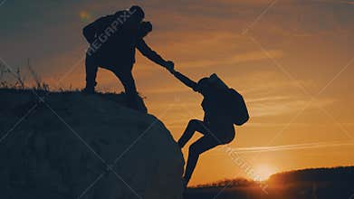 Couple hiking help each other silhouette in mountains. Teamwork couple hiking, help each other, trust assistance, sunset