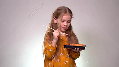 Little girl licks sushi sticks and keeps box rolls