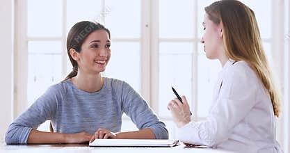 Young woman patient talking to female doctor at medical checkup