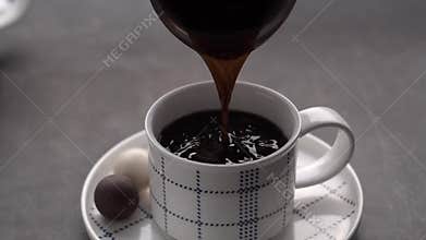 Pouring just made morning coffee in cup.