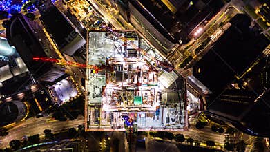 4K hyperlapse time-lapse of under construction site, crane, and car traffic transportation at night in city. Drone aerial top