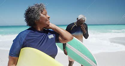 Front view old couple with surfboards at the beach