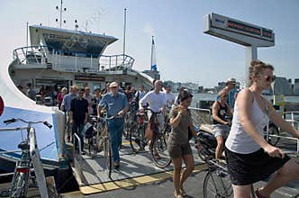Cyclists and pedestrians on ferryboat arrival, Amsterdam.