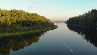 Flying a drone over a scenic spot on a winding river that reflects large, dense trees