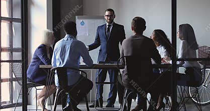 Smiling businessman leader give business presentation teach diverse executive group