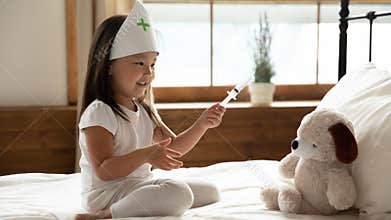Little Asian girl act as nurse cure plush toy