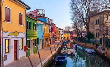 Lovely house facade and colorful walls in Burano, Venice. Burano island canal, colorful houses and boats, Venice landmark, Italy.