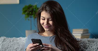 Portrait of stunning woman with mobile phone at home