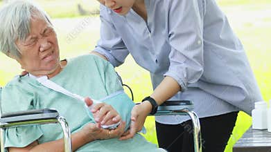 Injured asian senior woman wearing elbow support suffering from arthritis,sore muscle,elbow arm pain, joint disease or myositis, u