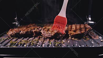 Delicious juicy meat steak cooking on grill. Prime rare roast grilling beef. Electric roaster, rosemary black pepper