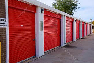 Row of storage garage units with red doors