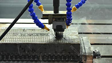 The EDM machine operation with liquid coolant method.