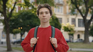 Young Caucasian Handsome Man Tourist Outside Wearing and Holding Backpack While Standing. Serious Male, Standing in City