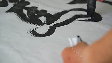 A famous Chinese calligrapher writes with a brush, creating a calligraphy work