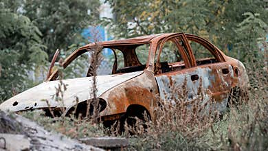 blown up car against the background of a destroyed house war between Russia and Ukraine