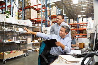 Business Colleagues Working At Desk In Warehouse