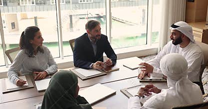 Five multicultural businesspeople solve business in modern office