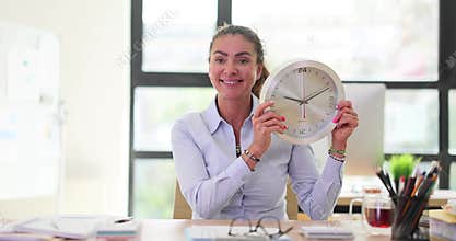 Portrait of responsible woman with clock in office