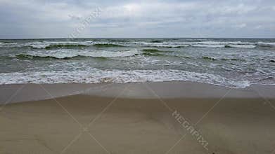 Medium sized waves crushing on sandy beach