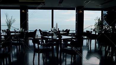 Spacious panoramic restaurant interior in evening dusk. Business lunch concept
