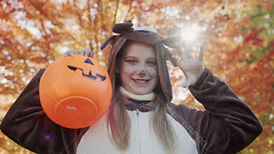 Portrait of a child in a deer costume with a basket for collecting sweets. Autumn holidays - Halloween