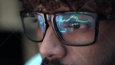Focused crypto trader analyst wearing eyeglasses working looking at computer.