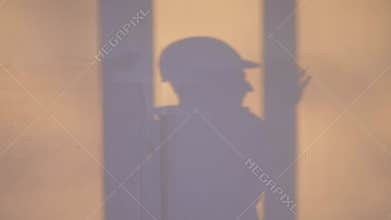 builder shadow falls on the wall silhouette. business building concept. worker in a helmet silhouette shadow falls on